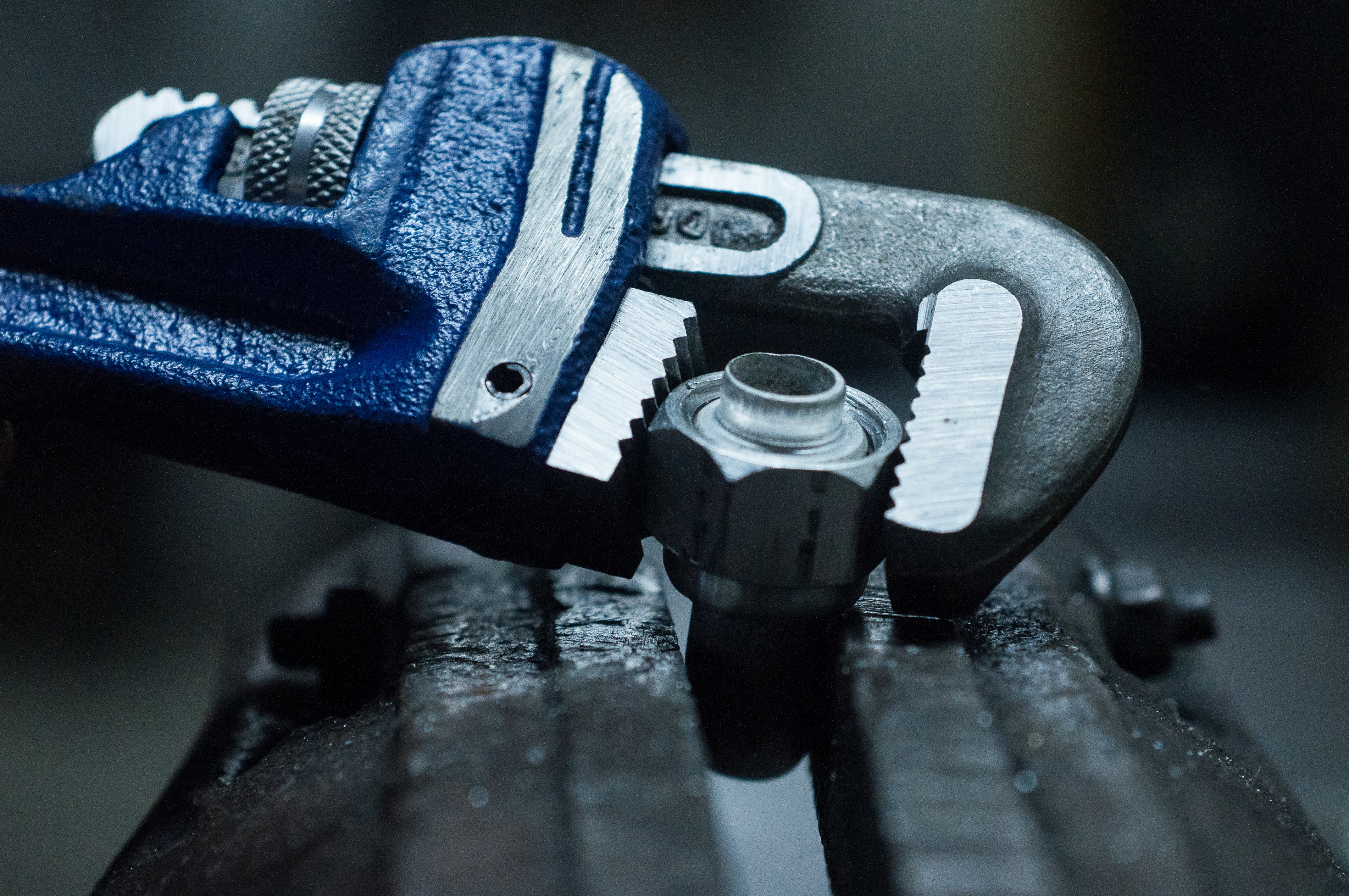 Clé serrant écrou métallique sur machine industrielle.